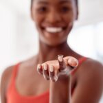 Woman holding a contact lens on her fingertip, illustrating safe contact lens use